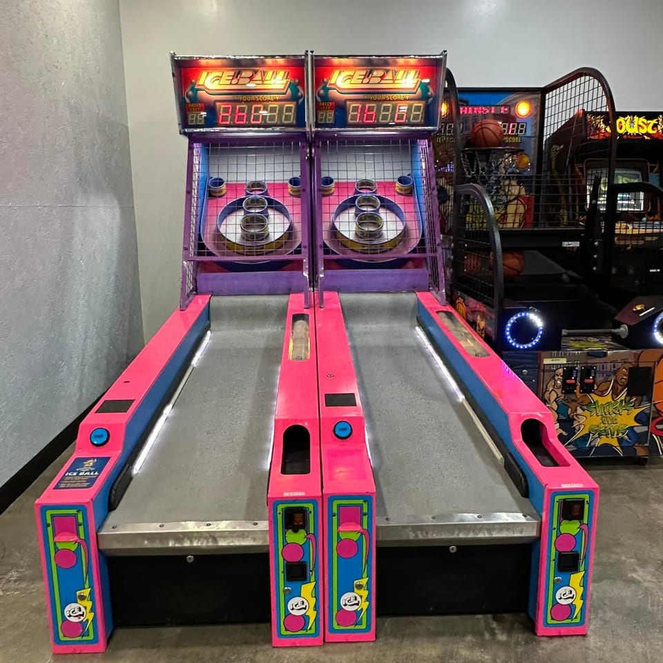 Two bright pink and blue Ice Ball arcade games stand ready for play at Decades Family Restaurant.