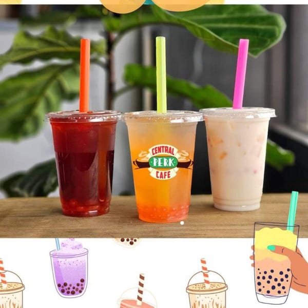 Three bubble tea drinks on a wooden surface, one with a Central Perk Cafe logo.