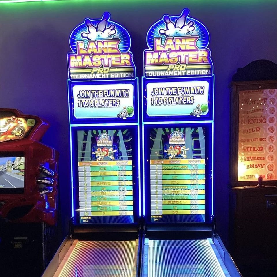 Two glowing blue Lane Master arcade bowling games stand ready for play at Decades Family Restaurant.